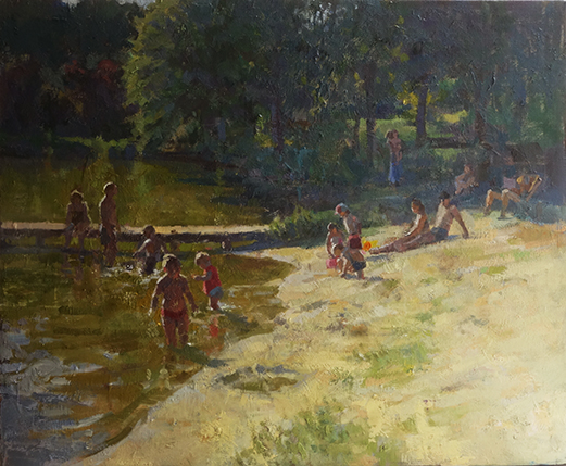 children playing in the water at the edge of the lake in the golden evening light.